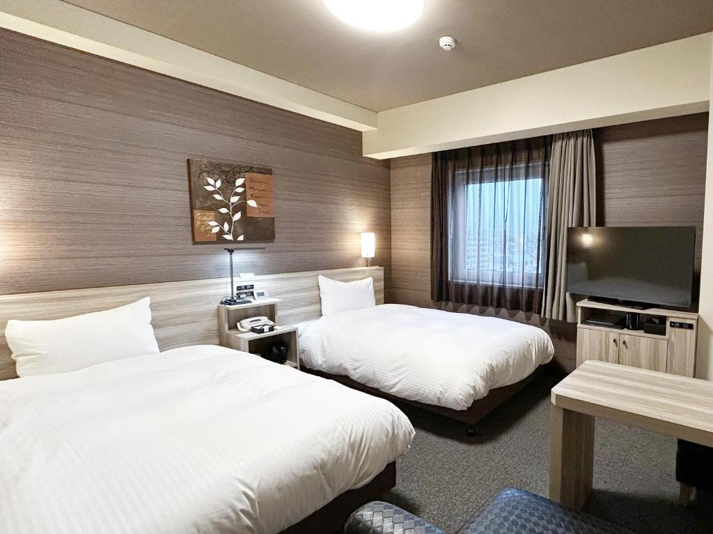 Postel nebo postele na pokoji v ubytování Hotel Route-Inn Shinshiro