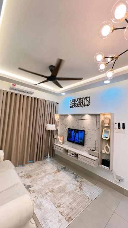 a living room with a ceiling fan and a tv at Inara Homestay in Kuala Lumpur