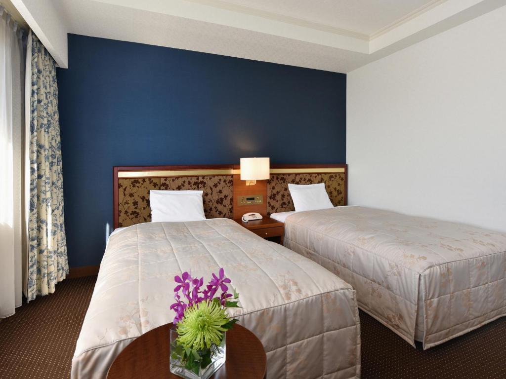 Postel nebo postele na pokoji v ubytování Hotel Crown Palais Chiryu