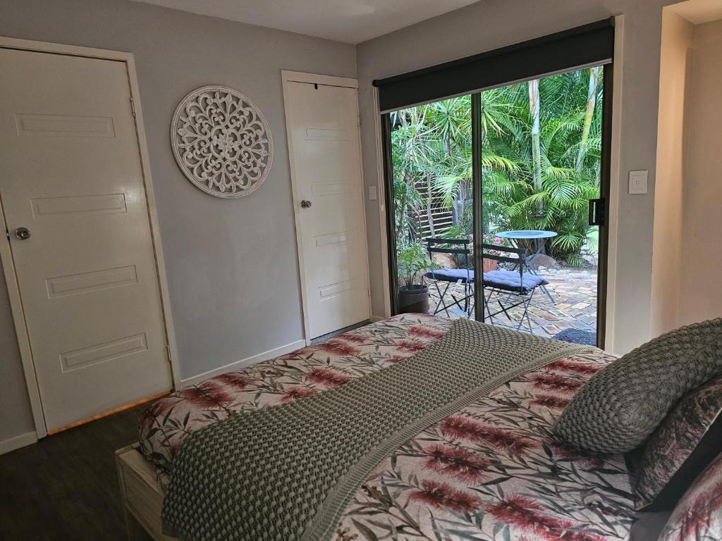 a bedroom with a bed and a door to a patio at The Garden House BnB in Barellan Point