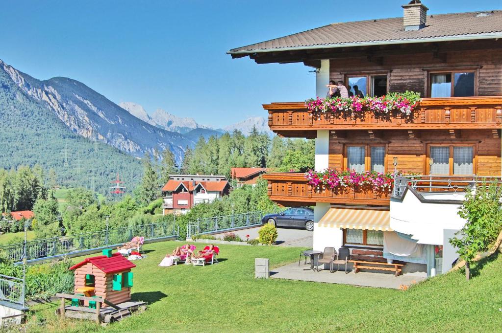 eine Gruppe von Menschen, die auf dem Gras vor einem Haus sitzen in der Unterkunft Appartementhaus Lechner in Arzl im Pitztal