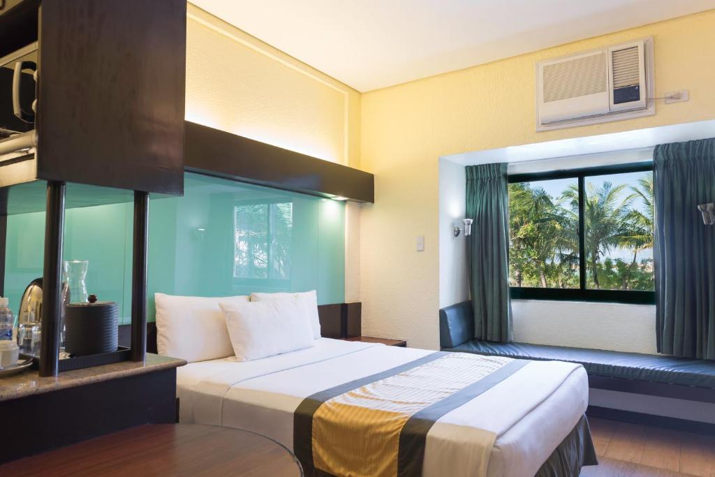 Postel nebo postele na pokoji v ubytování Microtel by Wyndham Cabanatuan