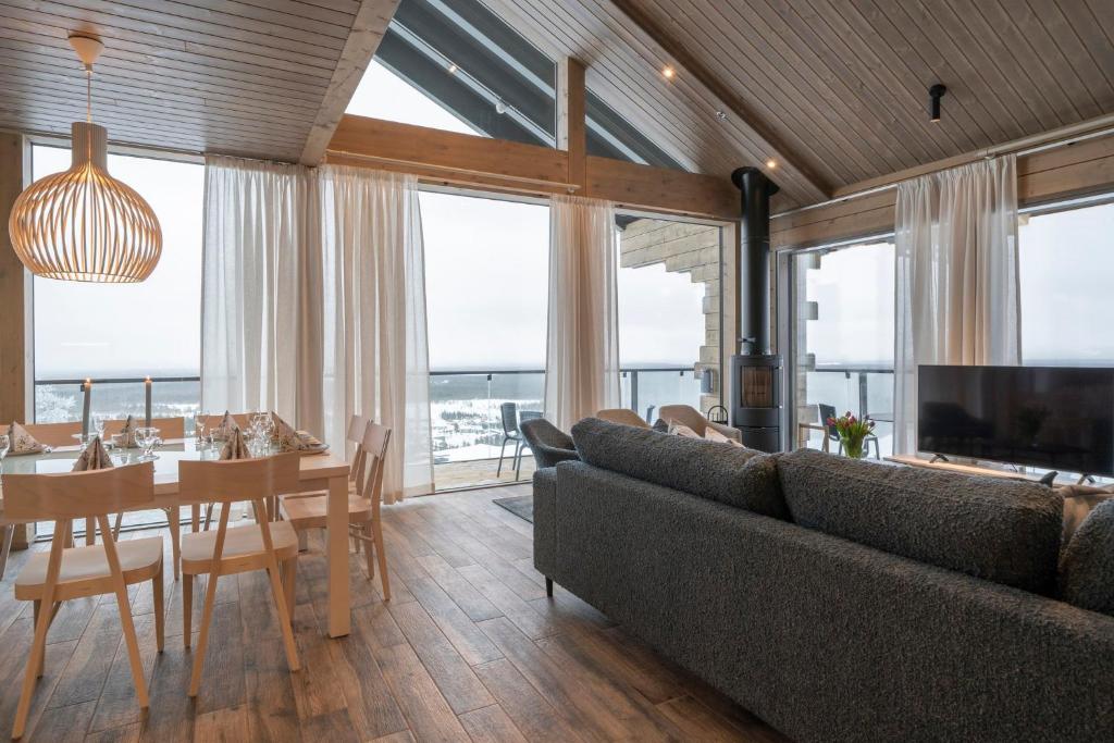 a living room with a couch and a table and a dining room at Ski-Inn Kultakero Penthouse in Pelkosenniemi