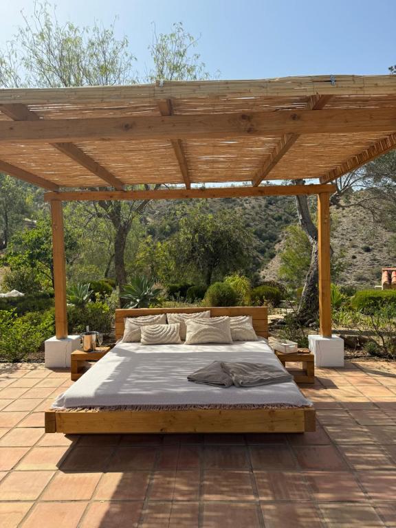 皮萨拉Santa Teresa Bed & Breakfast Andalusien的天井上木凉棚下的一张床位