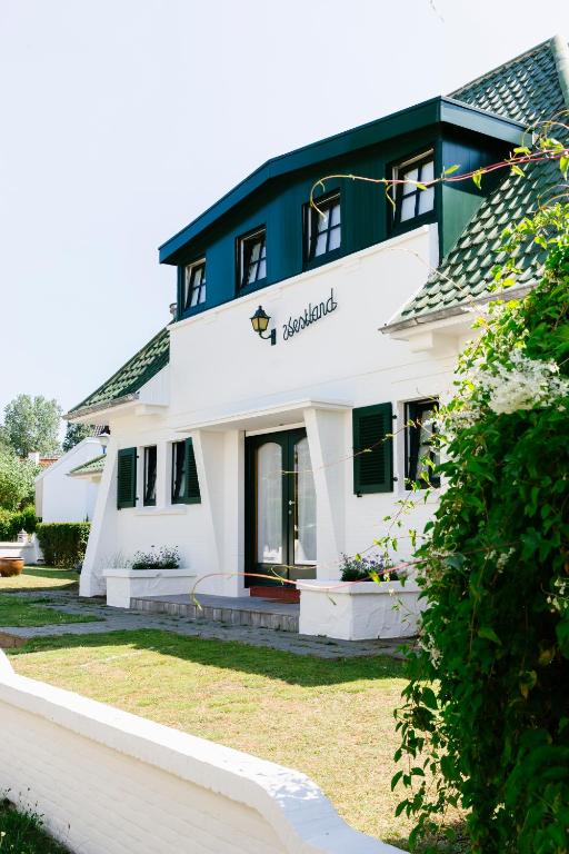 a large white building with a sign on it at Villa Westland in Koksijde