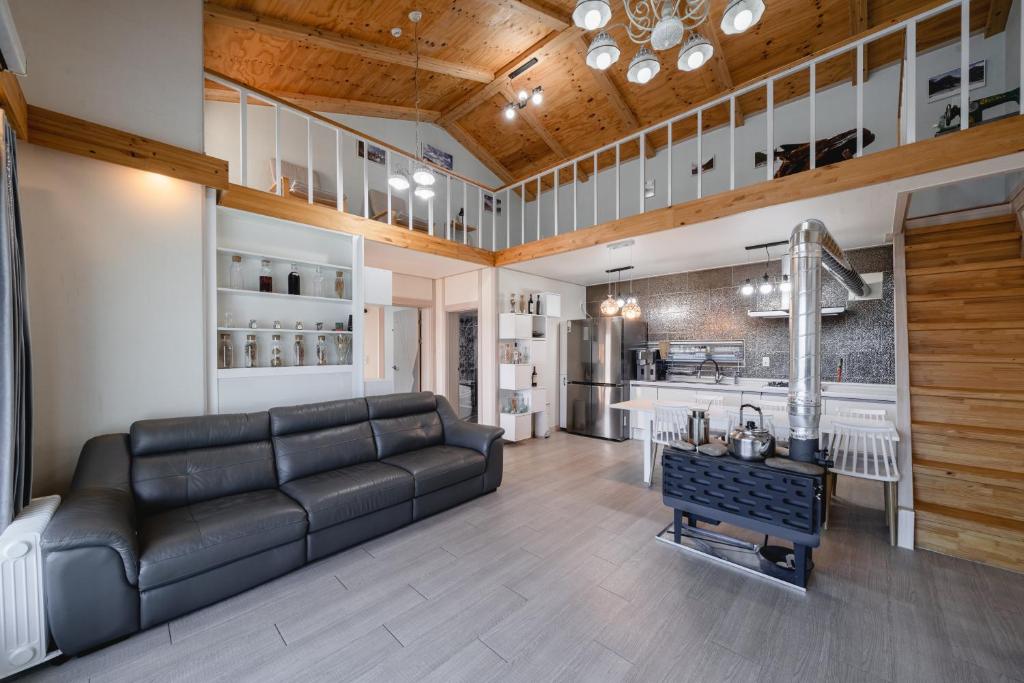 a living room with a couch and a kitchen at Yeoncheon Shineunsigan Pension in Yeoncheon