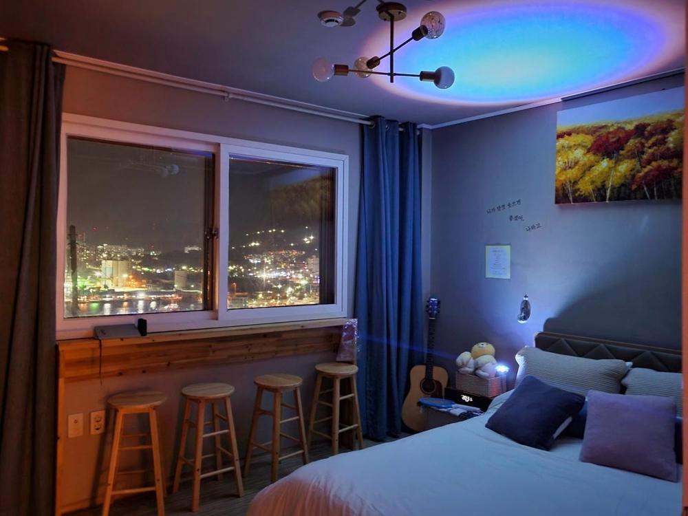 a bedroom with a bed and a bar with stools at Donghae Mookhoae Pension in Mukho-dong