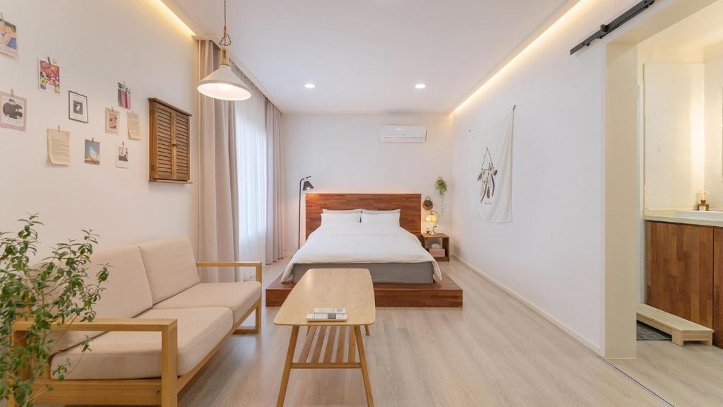 a bedroom with a bed and a couch and a table at Yangyang Stay Wabom in Yangyang