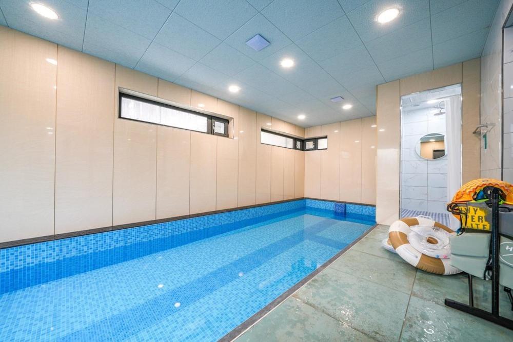 a large swimming pool in a room with a swimming pool at GaPY Mom Stay Private Pool Villa in Gapyeong