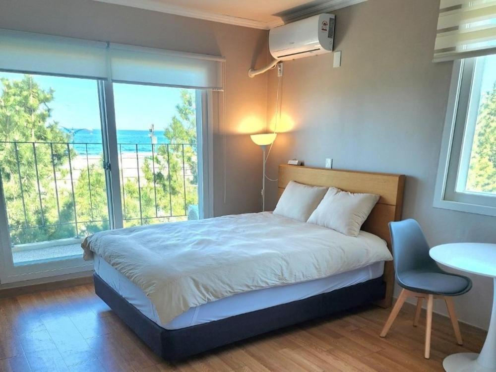 a bedroom with a bed and a large window at Yangyang Happy House Pension in Ka-kōtei-ri