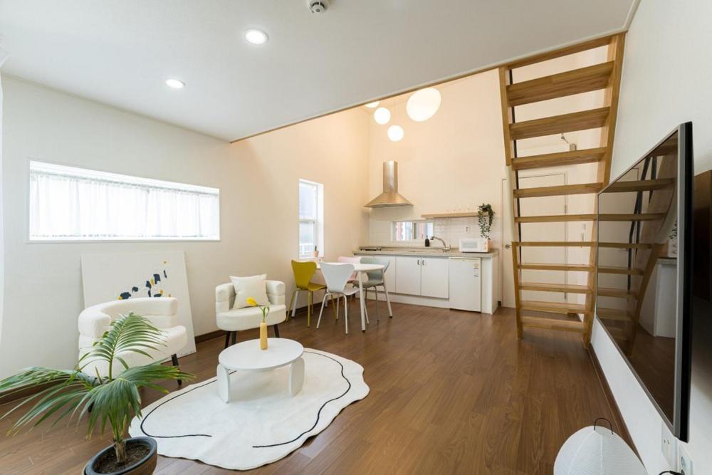 a living room with a staircase and a kitchen at Paju Stay 29 in Paju