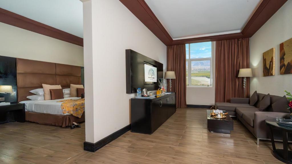 a hotel room with a bed and a couch at Mangrove Hotel in Ras al Khaimah
