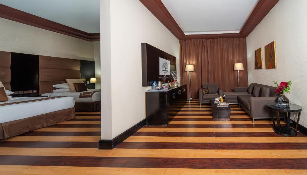 a hotel room with a bed and a living room at Mangrove Hotel in Ras al Khaimah
