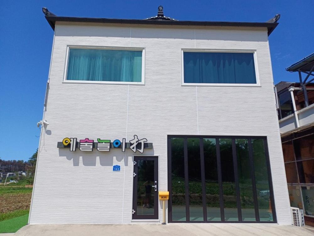 a white building with a sign on the side of it at Gangneung Nemo’s Dream Pension in Gangneung