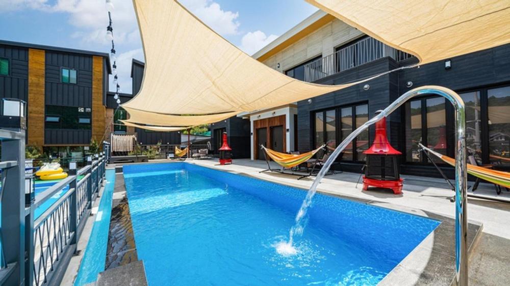 a pool with a water slide in a building at Gapyeong Casabella Pool Villa in Gapyeong