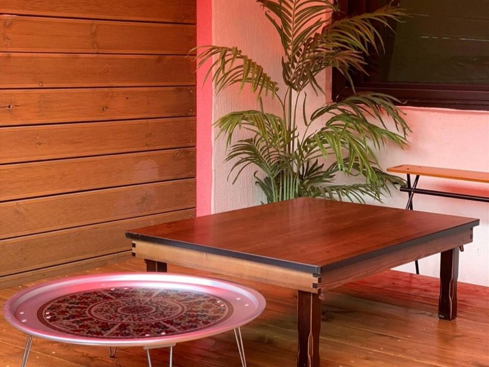 a table and a stool in a room with a plant at Gapyeong Imchori Buttumark Pension in Gapyeong