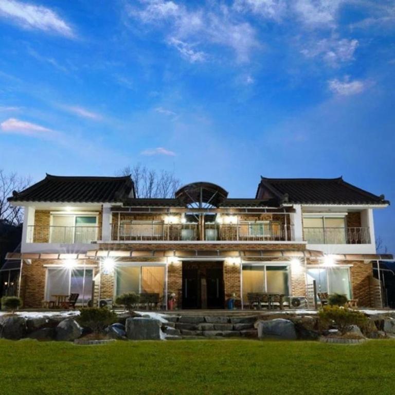 a large brick house with lights in the yard at Yanggu Dandelion Pension in Yanggu