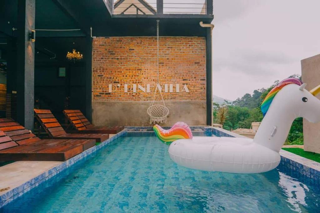a pool with an inflatable pool swing and an inflatable unicorn at D Pine Villa in Bukit Tinggi