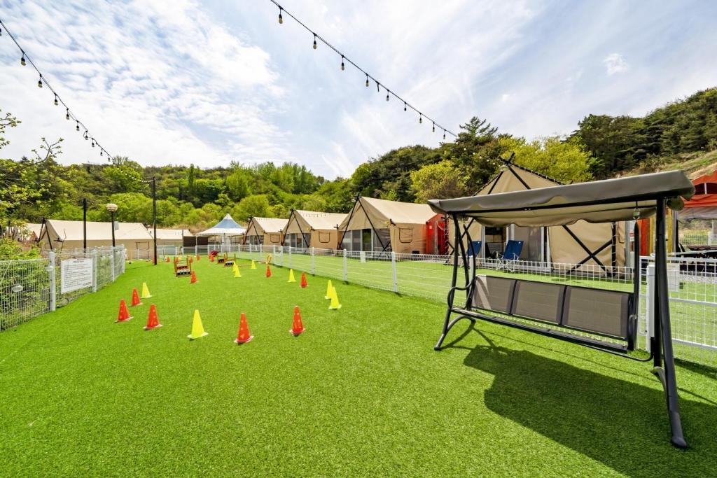CheongdoにあるCheongdo Shinnanda Aegyeon Glampingの芝生の上にオレンジのコーンがあるテニスコート