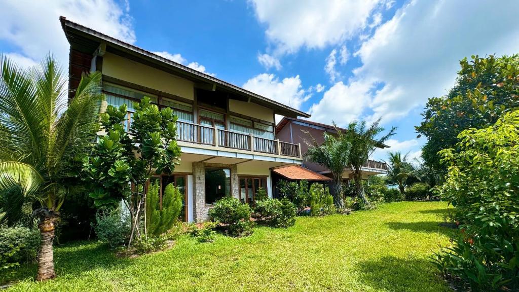 eine Außenansicht eines Hauses mit Garten in der Unterkunft The Cottage Hồ Tràm hills in Thuận Biên