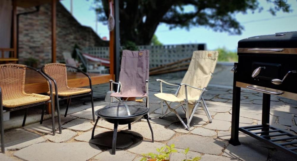 a group of chairs and a grill on a patio at Namhae Celties Pension in Namhae