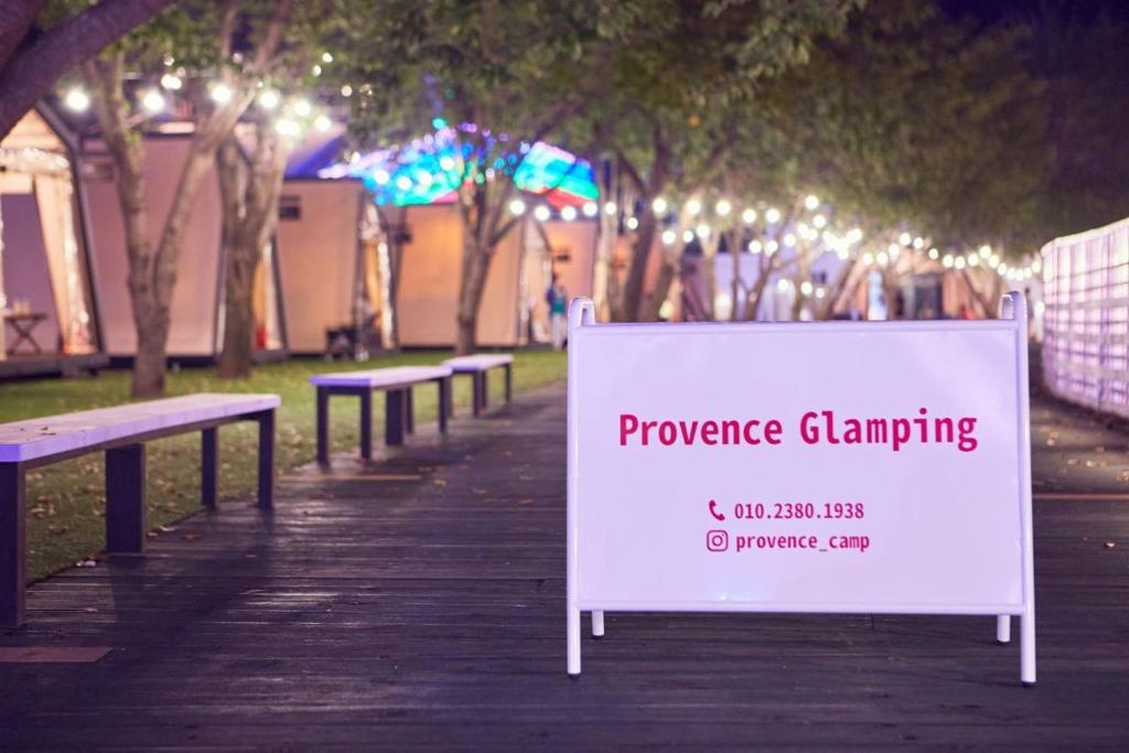 a sign on a boardwalk in a park with benches at Cheongdo Provence Glamping in Cheongdo