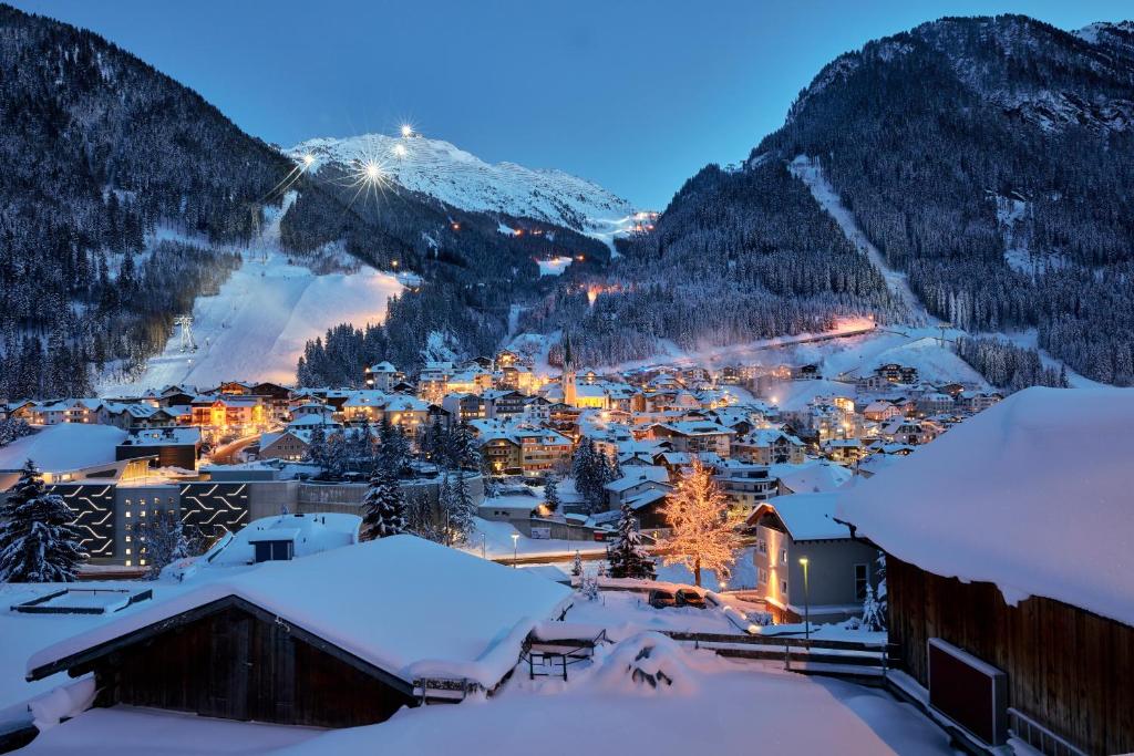 eine Stadt voller Schnee in der Nacht mit Bergen in der Unterkunft Chalet Madlein in Ischgl