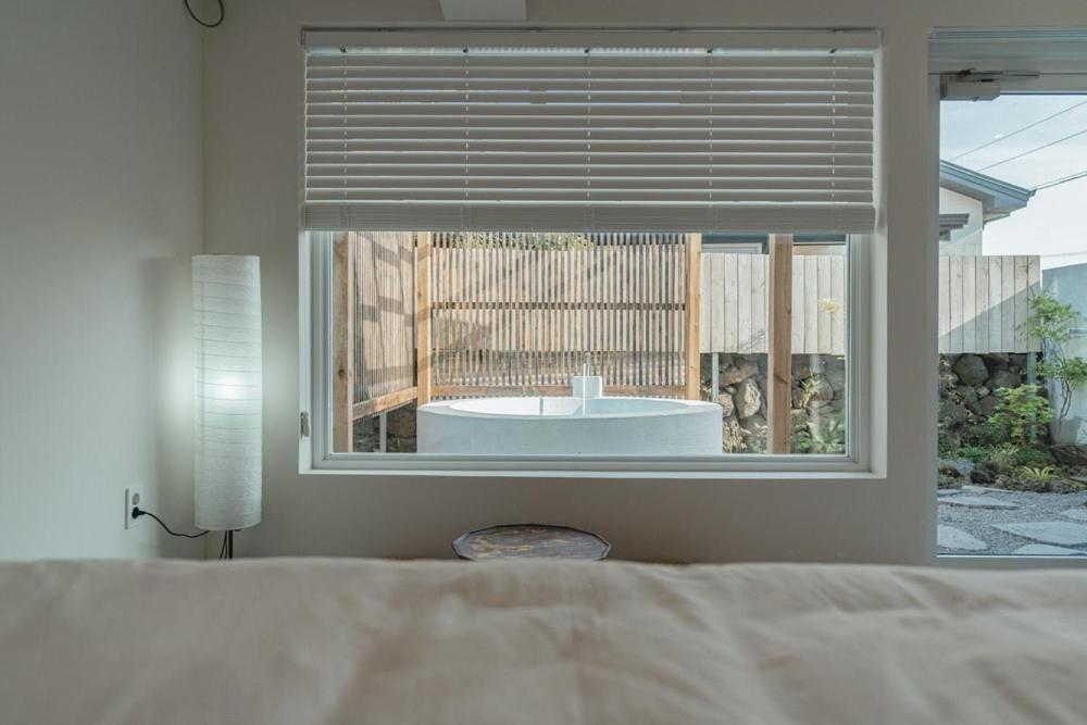 Кровать или кровати в номере Jeju Mureungri The house