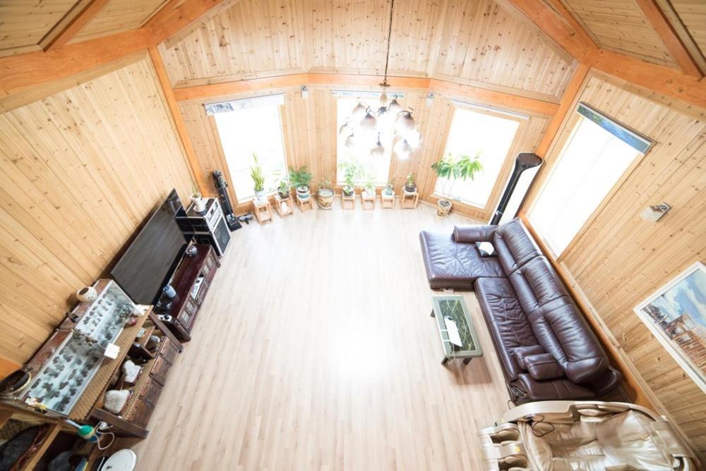 une vue aérienne d'un salon avec un canapé et des chaises dans l'établissement Jeju Woongine Pension, à Jeju