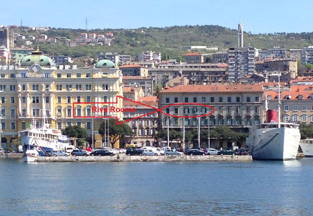 a city with a harbor with a boat in the water at Riva Rooms in Rijeka
