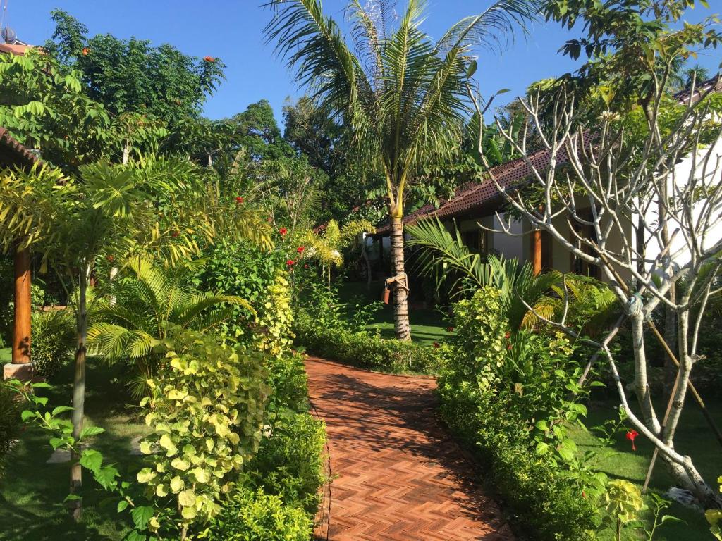 a path leading to a house with trees and plants at La Mer Resort, Phú Quốc in Phú Quốc