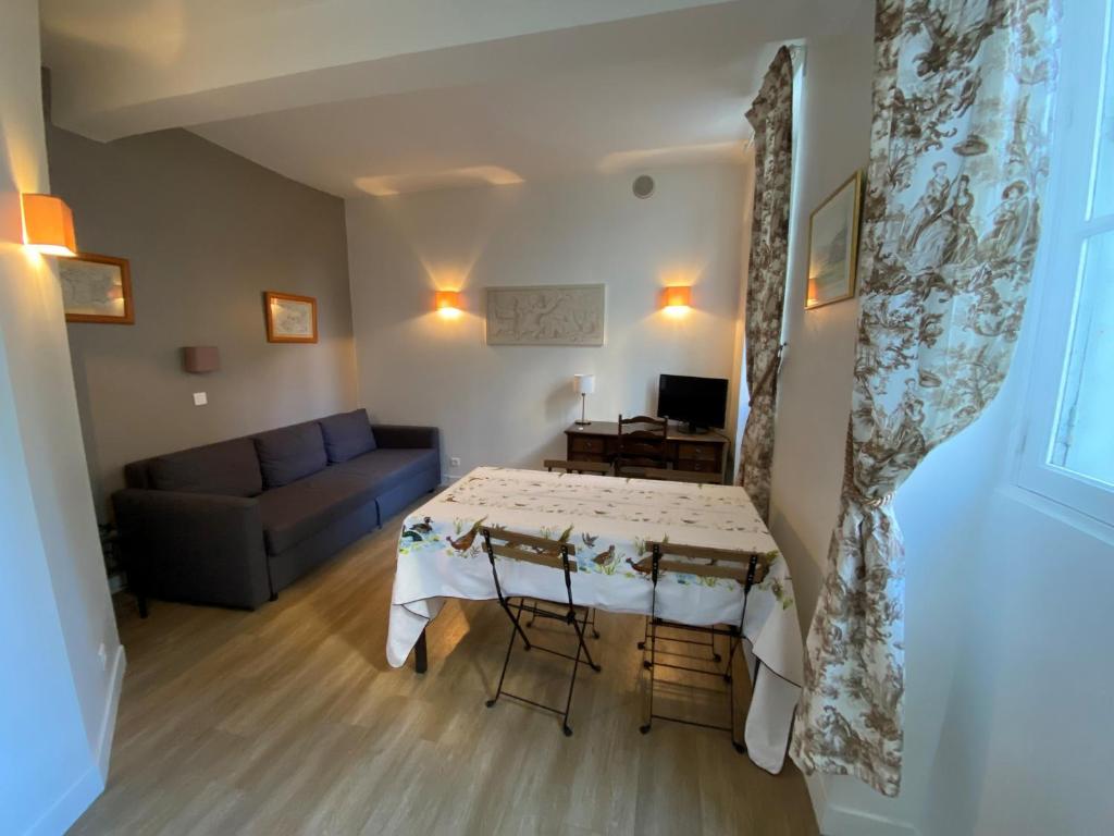 una sala de estar con una mesa y un sofá en Château de Versailles 800m à pied, en Versalles