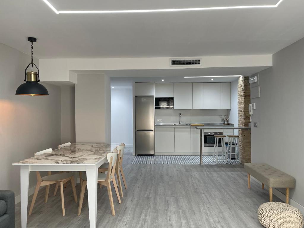Una cocina y una sala de estar con mesa y sillas. en Voix du Monde, en Tudela