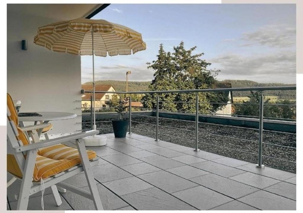 a patio with a table and an umbrella on a balcony at Ferienwohnung Aussichtsreich in Bad Pyrmont