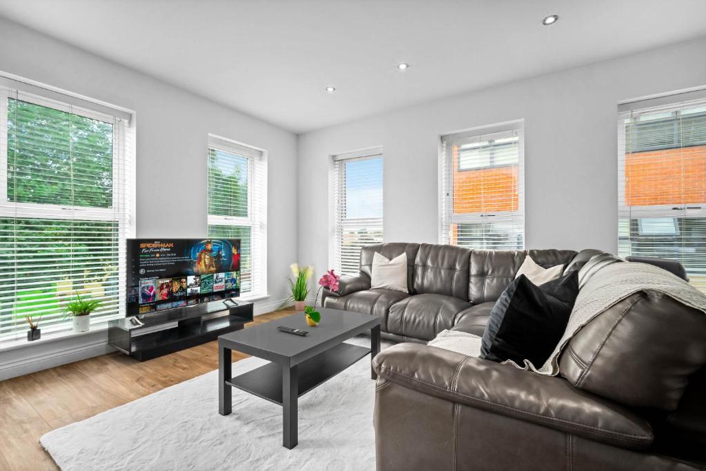 Hotel Modern Two Bedroom Apartment - Secure Parking - Birmingham City Centre - 195M, a living room with a leather couch and a table at Modern Two Bedroom Apartment - Secure Parking - Birmingham City Centre - 195M in Birmingham