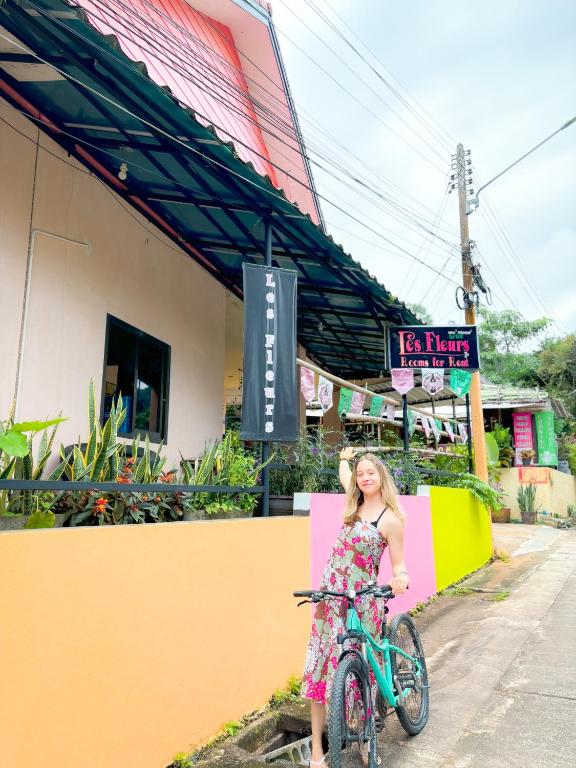 a young girl in a dress standing next to a bike at Les Fleurs House in Khao Lak
