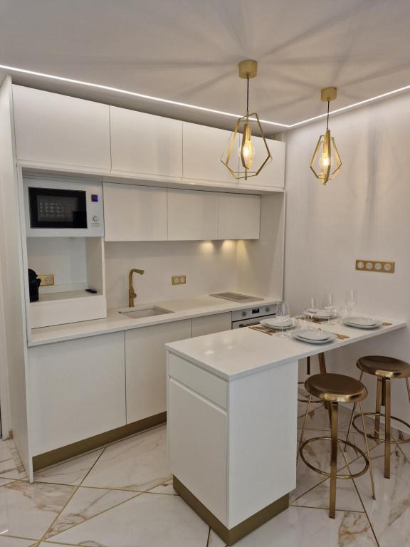 une cuisine blanche avec un évier et un comptoir dans l'établissement Appartement - Montmartre, à Paris