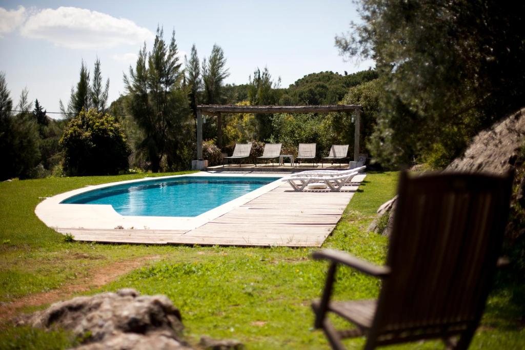 a swimming pool in a yard with chairs around it at Ha Mar ao Luar in Setúbal