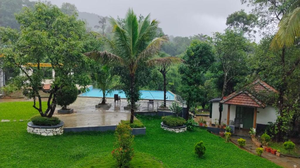 a resort with a pool in the middle of a yard at Gavadana Resort Coorg in Madikeri