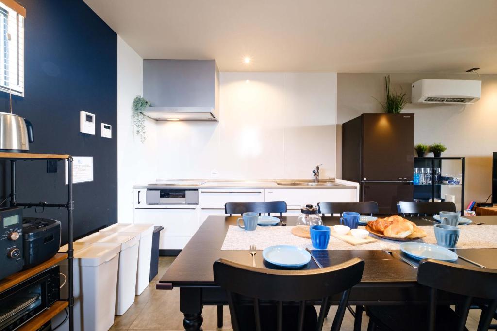 eine Küche mit einem Tisch und Stühlen in einer Küche in der Unterkunft Urban Resort Villa ILILANI in Inbu