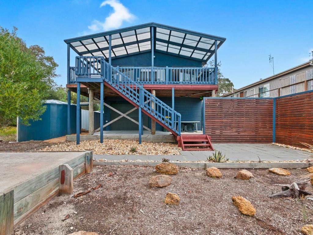Un edificio con una escalera azul en un patio. en Chez Reeve, en Lock Sport