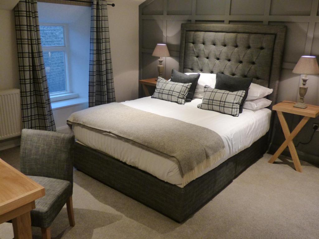 um quarto com uma cama grande e uma cadeira em The Fenwick Steak & Seafood Pub em Lancaster