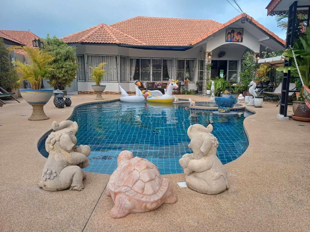a group of stuffed animals sitting next to a swimming pool at Phala Sunshine Villa in Ban Phala