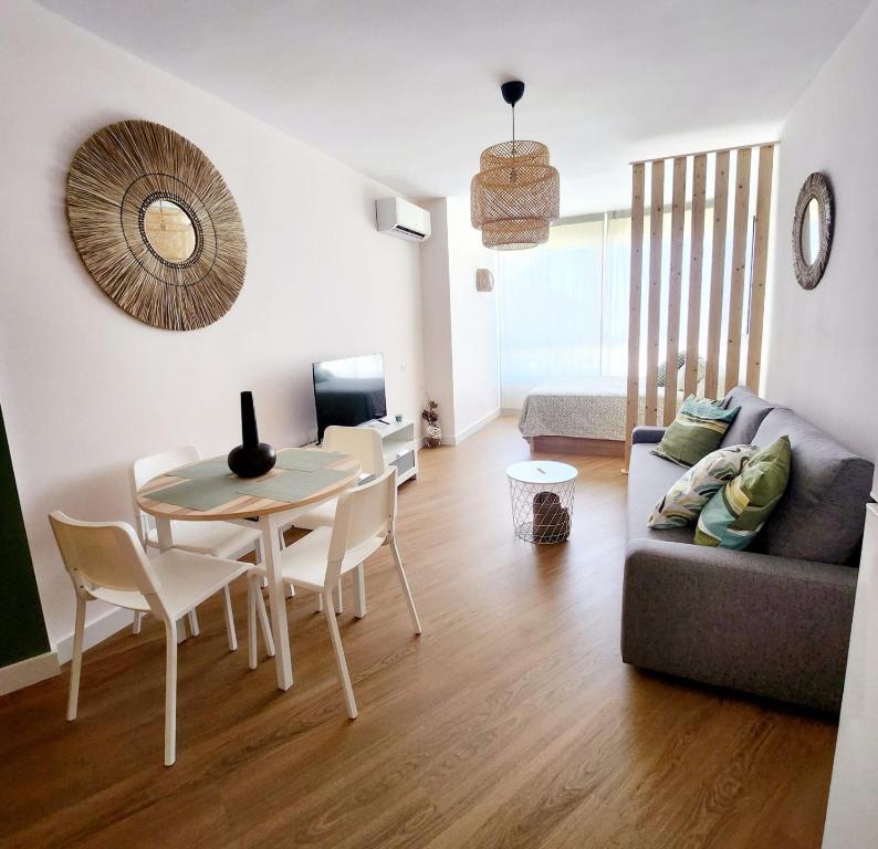 a living room with a table and a couch at Estudio MELMAR en Playamar in Torremolinos