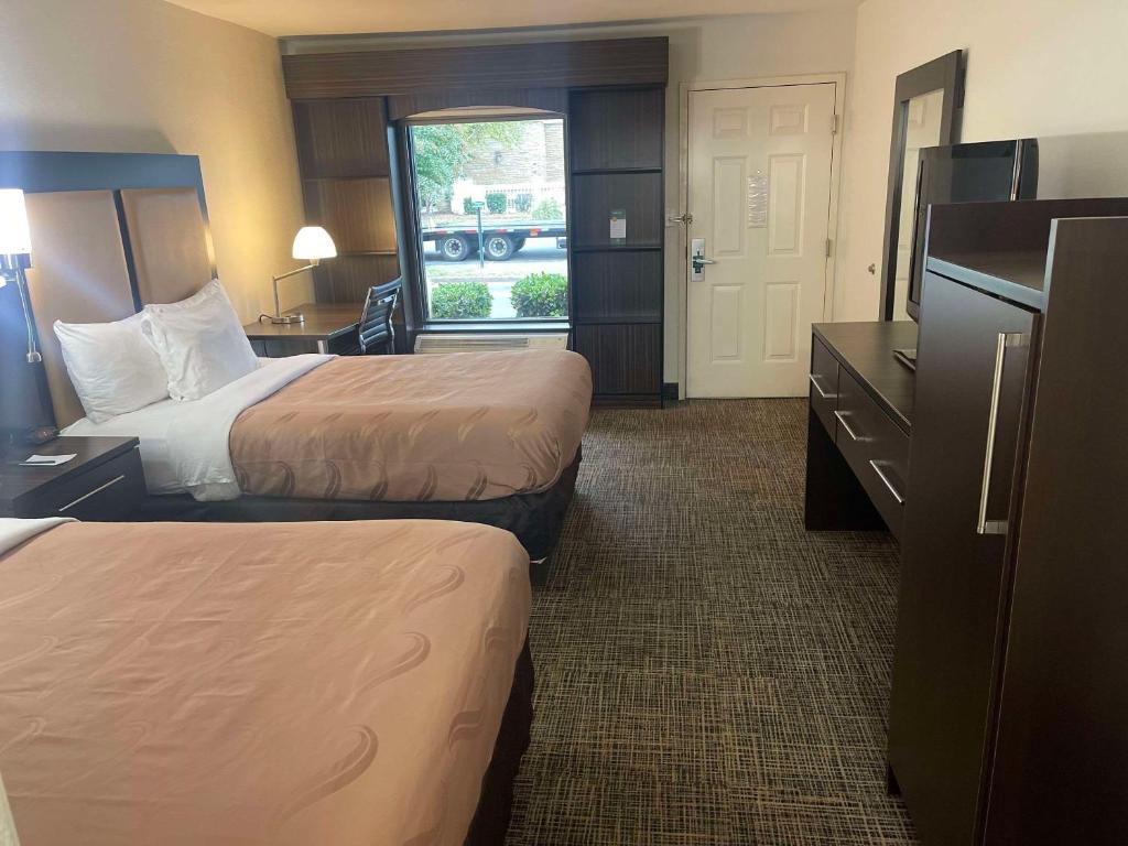 a hotel room with two beds and a desk at Quality Inn Dalton Central in Dalton