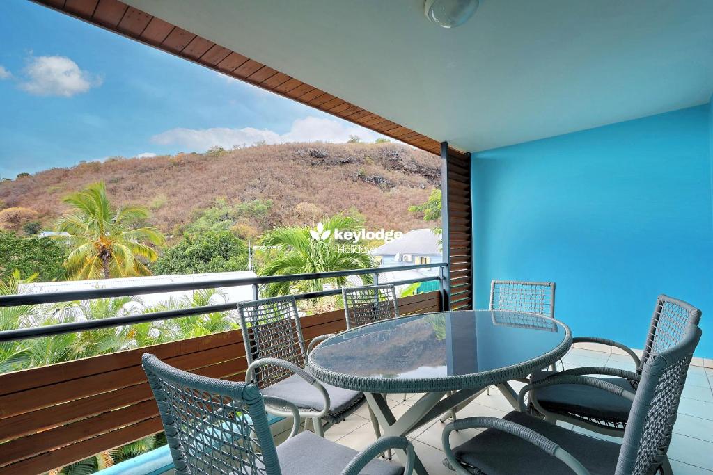 einen Balkon mit einem Tisch, Stühlen und einem Berg in der Unterkunft Leu Ty Kosy - T3 en plein centre-ville - Saint-Leu in Saint-Leu