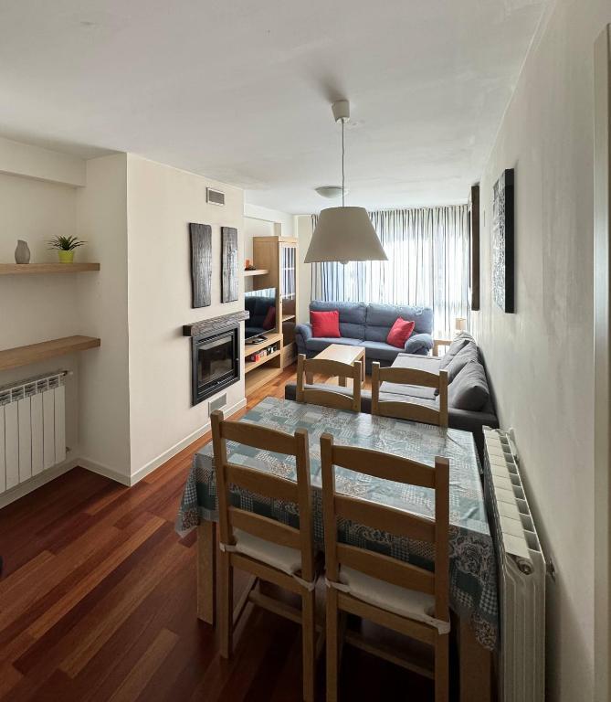 a living room with a table and chairs and a couch at Margas Golf Apartment in Sabiñánigo