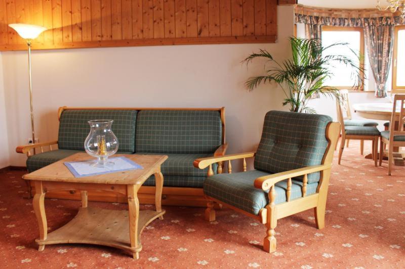 een woonkamer met een bank, een tafel en stoelen bij Himmelbauer Apartments in Söbriach