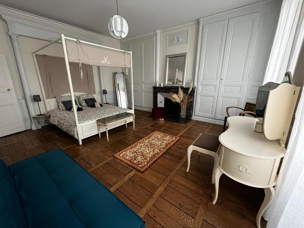 a living room with a bed and a desk at La Villa Louana 1 Appartement 160m2 sobriété,élégance en cœur de ville in Aubusson