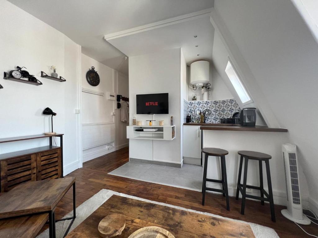 une cuisine avec une table et deux tabourets de bar dans l'établissement Studio proche Paris - Saint Ouen - 2 PAX, à Saint-Ouen
